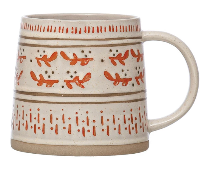 ceramic mug with festive, hand-painted designs featuring plants, patterns, and holiday-themed colors on a beige base.